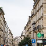 Charming rainy day in Montmartre with classic Parisian architecture and wet cobblestones.