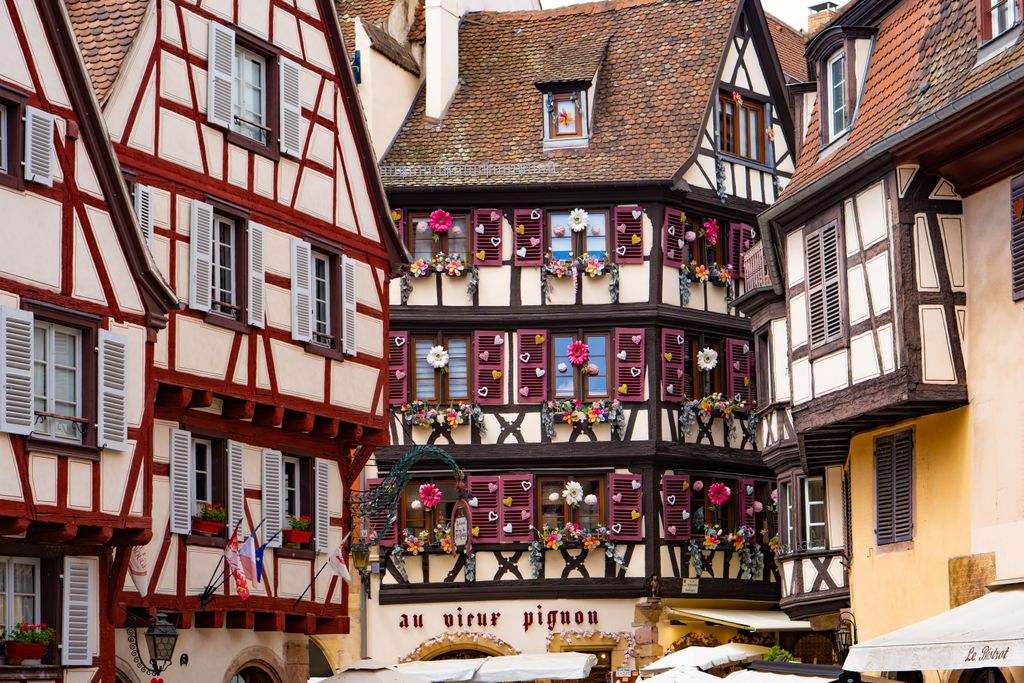 Traditional half-timbered houses in Colmar, Grand Est, France showcasing vibrant Alsatian architecture.